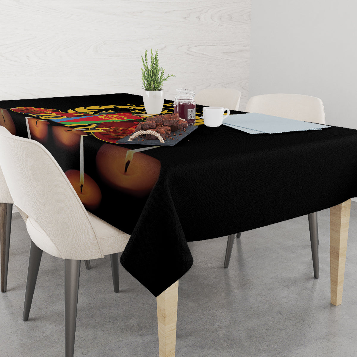 Black tablecloth with printed candles and colorful crest near center of table