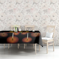 Black tablecloth with printed candles on tabletop at seated dining chairs