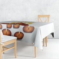 White tablecloth with candle-flame print, draped over table corner