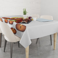 White tablecloth with candle-flame print on long dining table with chairs