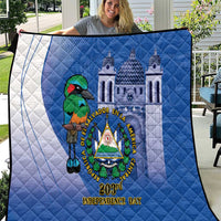 Blue quilt held outside showing bird-and-cathedral emblem and “203rd Independence Day” text