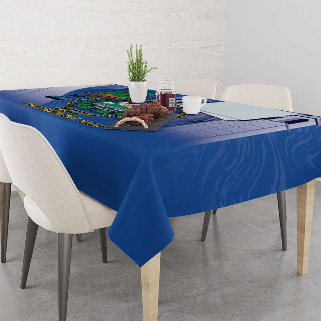 Blue tablecloth on dining table with bird emblem near the far edge
