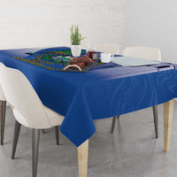 Blue tablecloth on dining table with bird emblem near the far edge