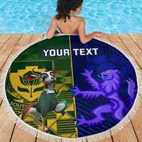 Round beach blanket with green left panel and blue right panel, tassel fringe, 'YOUR TEXT'