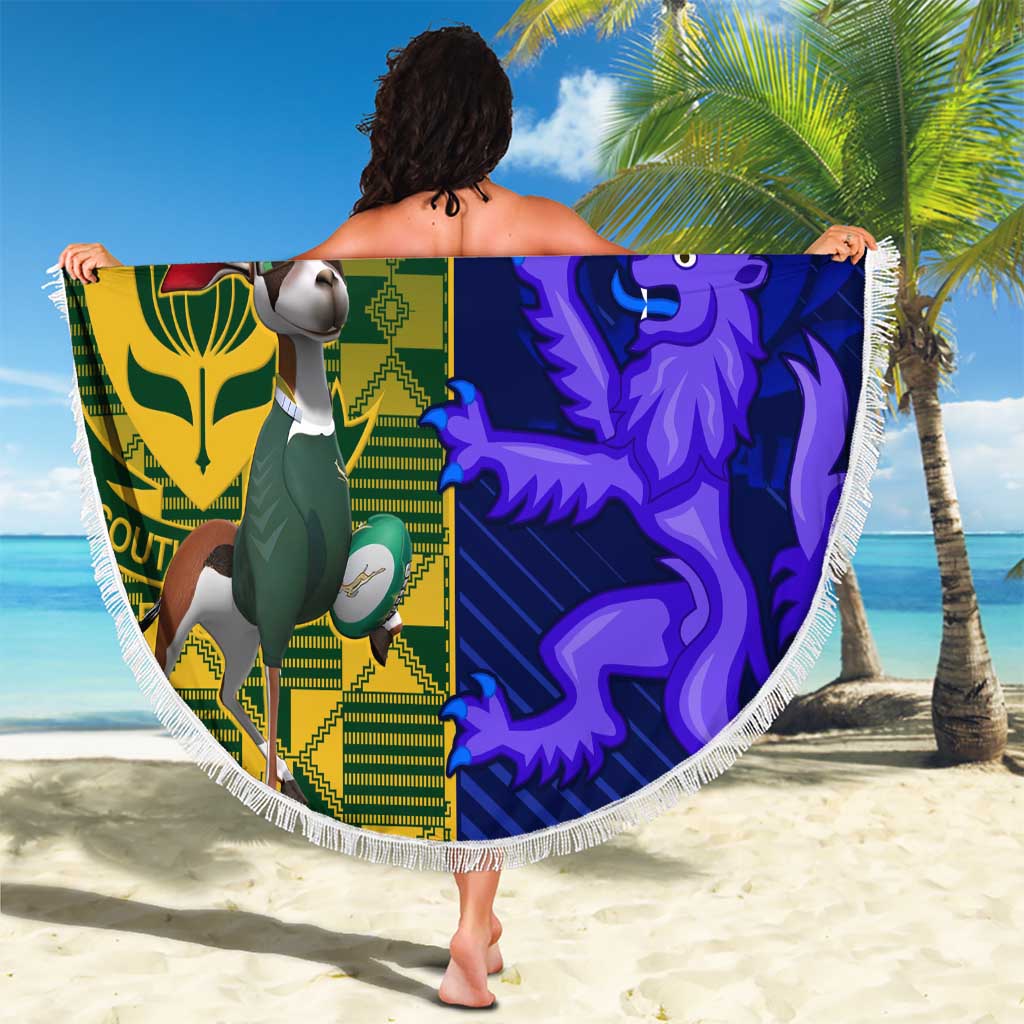 Round beach blanket with green and blue team-style panels, white tassel fringe border