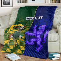 Rugby blanket on couch with green-left and blue-right artwork, crest and lion, "YOUR TEXT"