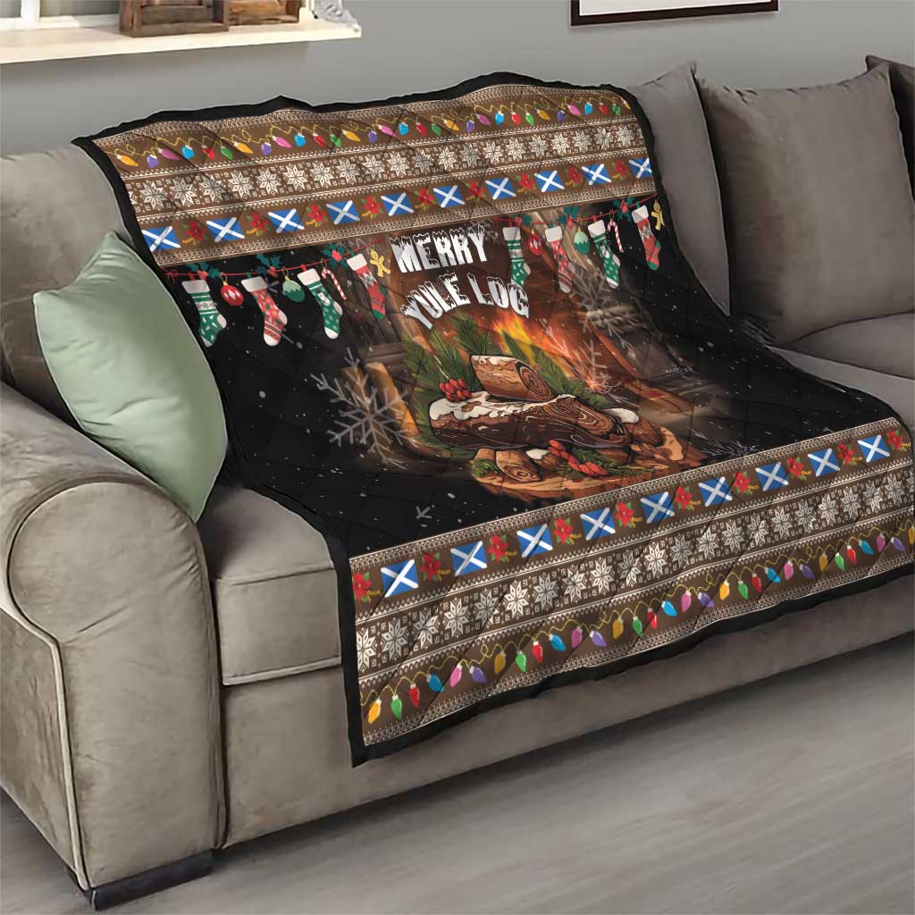 Dark quilt with Merry Yule Log center and folk border, draped over sofa arm.