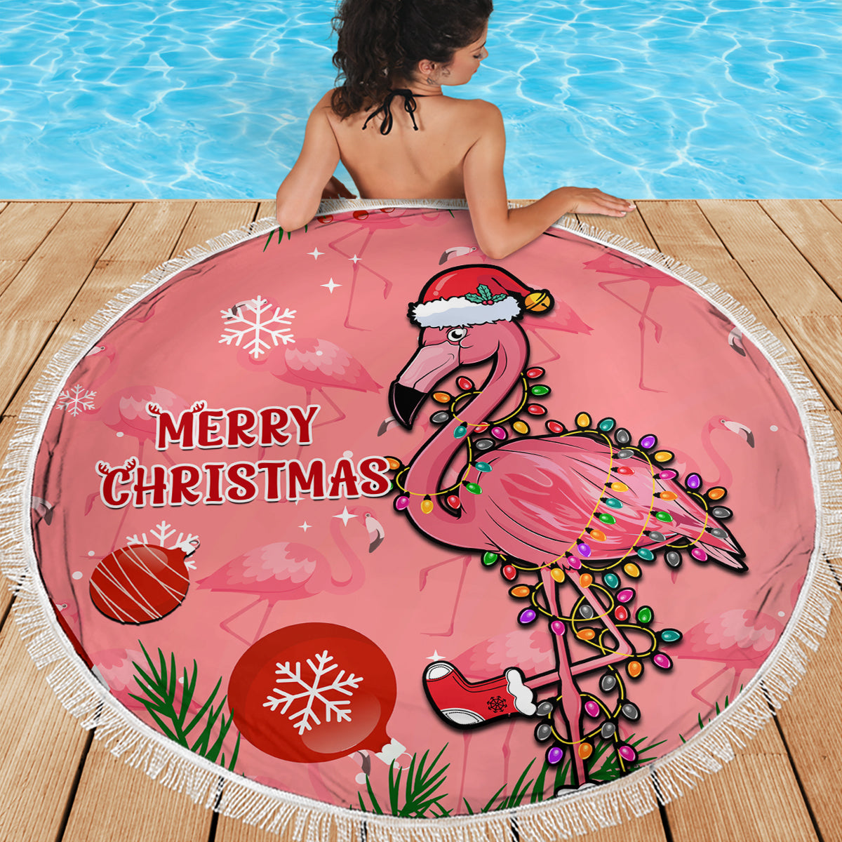 Pink round beach blanket showing flamingo in Santa hat and “Merry Christmas”