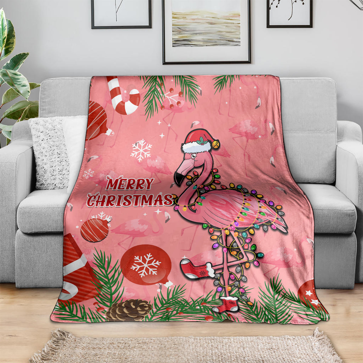 Pink throw blanket draped on sofa, cartoon flamingo and “Merry Christmas”