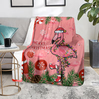 Pink flamingo throw blanket with “Merry Christmas” text, pine needles, and ornaments