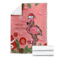 Pink flamingo Christmas blanket with “Merry Christmas” print, folded with white towel rolls