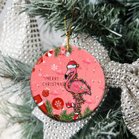 Pink round ceramic Christmas ornament on a tree, flamingo design with “Merry Christmas”