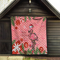 Pink flamingo holiday quilt hanging on a wooden wall with “Merry Christmas” text