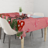 Pink flamingo Christmas tablecloth draped over a table with holiday pattern and stars