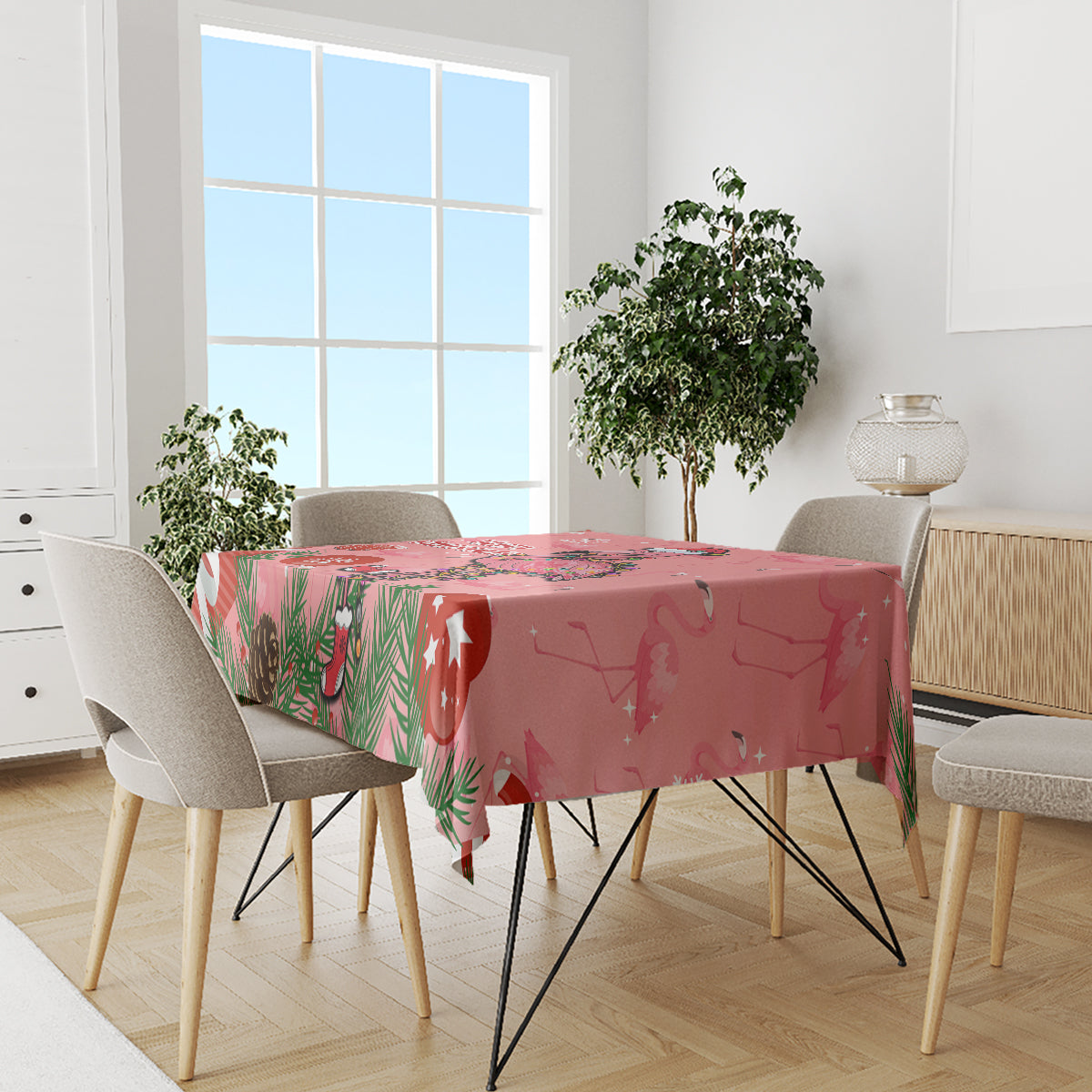 Pink flamingo Christmas tablecloth covering a dining table with festive border details