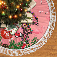 Pink flamingo Christmas tree skirt with white fringed trim and illustrated holiday motifs