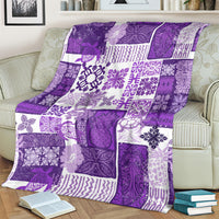 Purple patchwork quilt blanket with tiki tropical pattern blocks, draped over couch