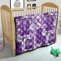 Purple and white quilt draped in a nursery, patchwork squares with floral print