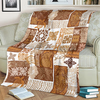 Brown tropical patchwork quilt blanket with tiki-style prints, draped on striped sofa