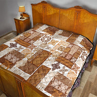 Brown and white patchwork quilt laid on a bed with tiki and floral motifs