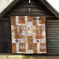 Brown patchwork quilt with white and tan tiki and floral patchwork blocks