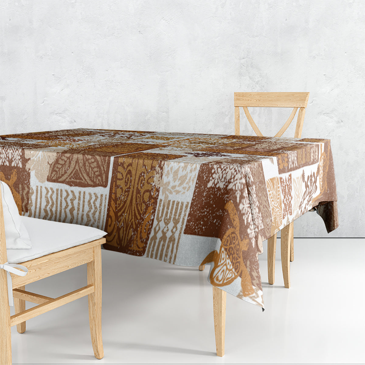 Brown quilt-style tablecloth corner with patchwork tiki and geometric motifs