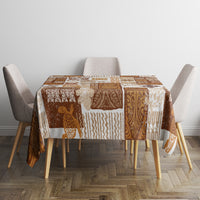 Brown quilt-style tablecloth with square patchwork tiki designs on a dining table