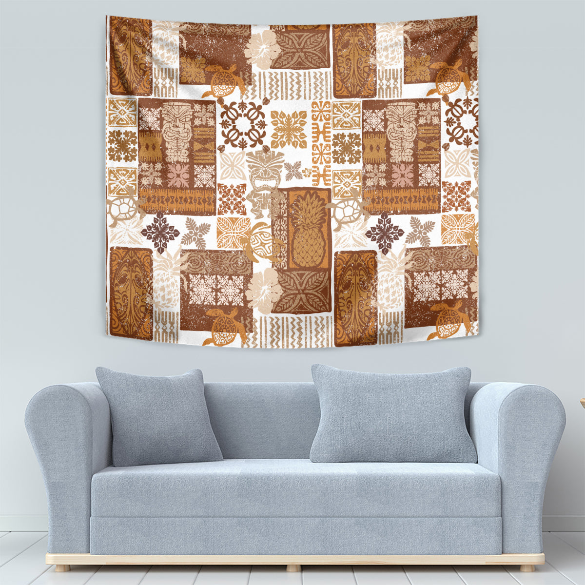 Brown tropical patchwork quilt tapestry with tiki figures, leaves, and tile-like blocks; hanging