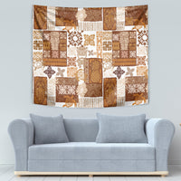 Brown tropical patchwork quilt tapestry with tiki figures, leaves, and tile-like blocks; hanging