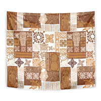 Tropical quilt tapestry close-up: brown, tan, and white patchwork with tiki and floral motifs