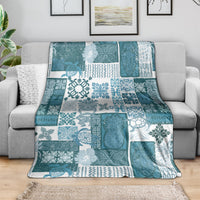 Dark cyan patchwork quilt blanket with white tropical motifs and geometric tile patterns