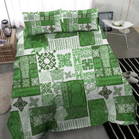 Green quilt bedding set with detailed tropical leaf and geometric squares; two pillowcases