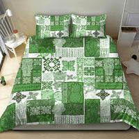Green quilt bedding set with bold patchwork tropical leaf and geometric motifs; two pillows