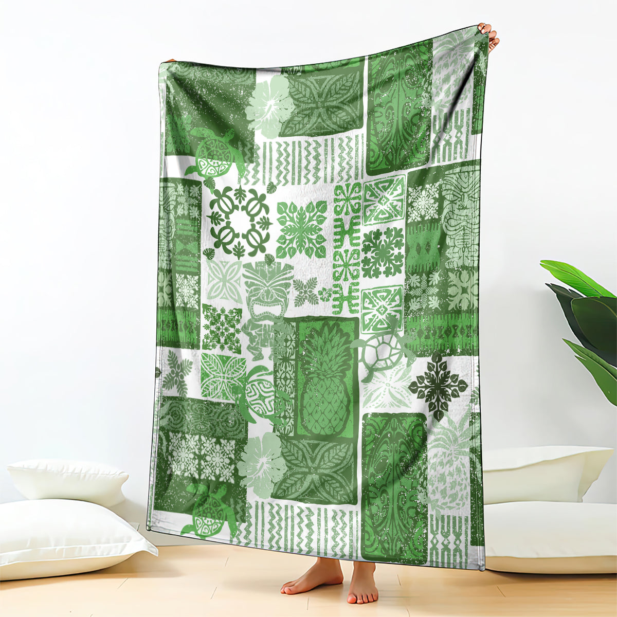 Green patchwork quilt blanket with tiki-inspired leaf and geometric patterns.