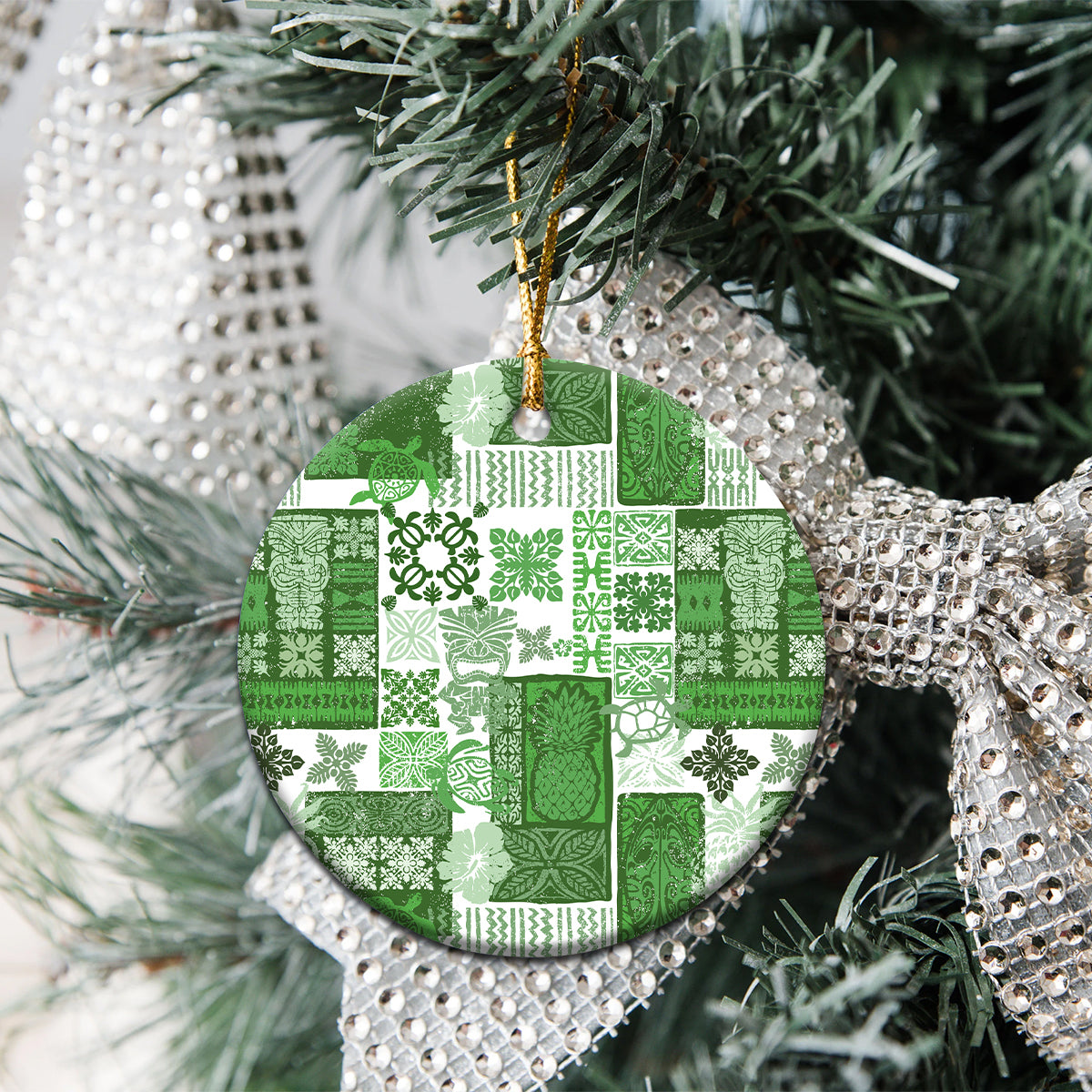Green patchwork ceramic round ornament with gold hanging loop on Christmas tree