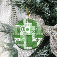 Green patchwork ceramic round ornament with gold hanging loop on Christmas tree