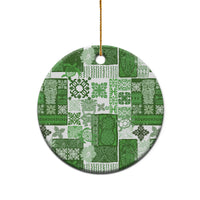 Green patchwork ceramic round ornament with gold hanging loop on white background