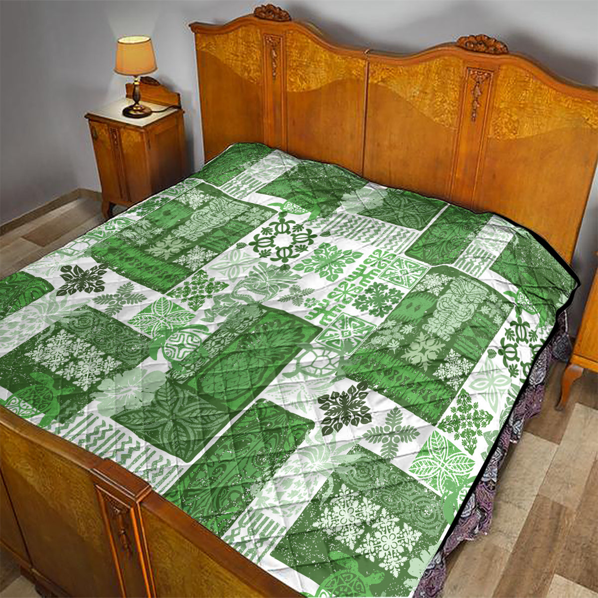 Green and white tiki patchwork quilt with tropical floral motifs and black-trim edge on bed