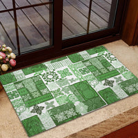 Green and white patchwork tiki quilt doormat with tiki and leaf motifs