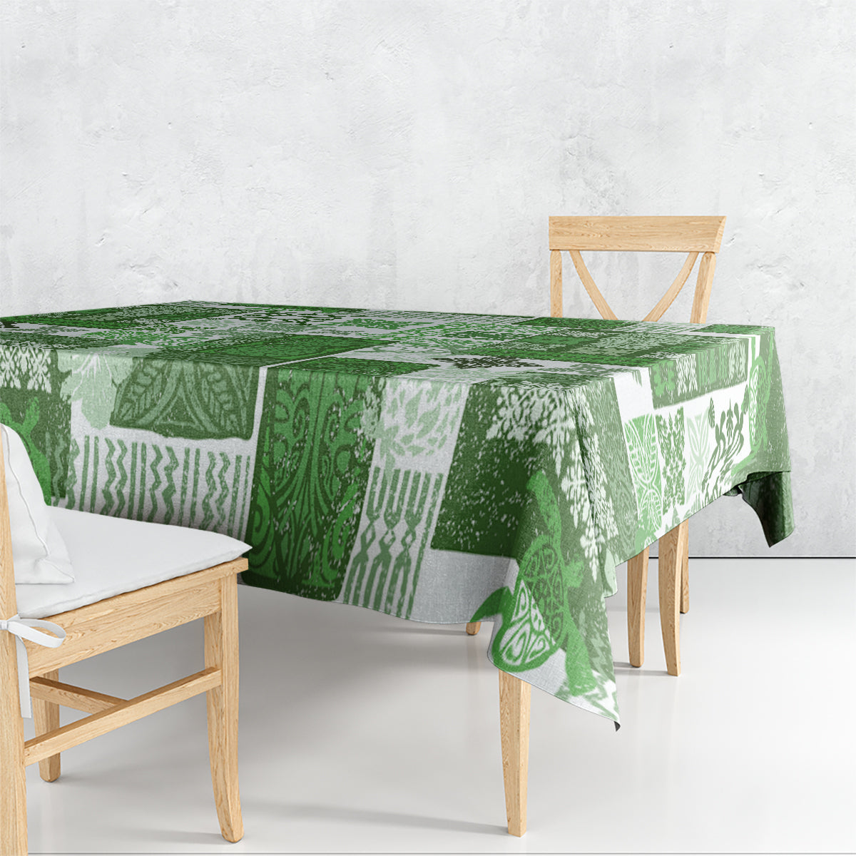 Green tiki patchwork tablecloth with patterned panels, draped over a dining bench table
