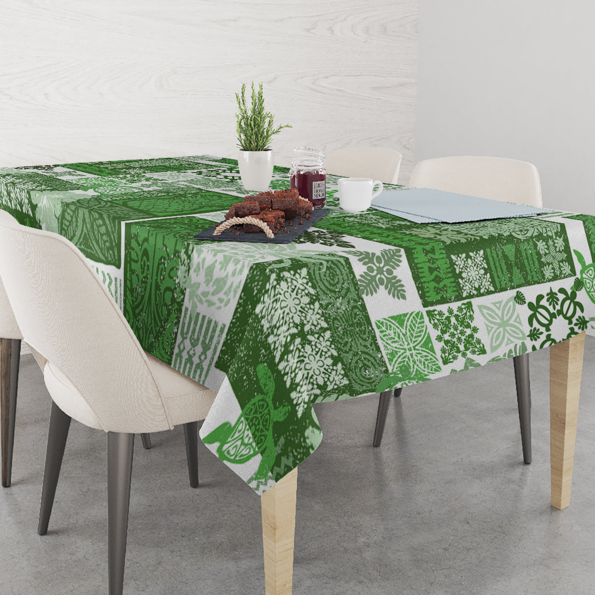 Green patchwork tiki tablecloth with floral and geometric designs on a dining table