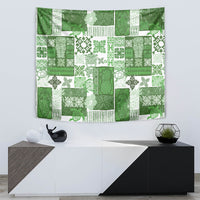 Green quilt-style tapestry with tiki and floral patchwork in white and dark green
