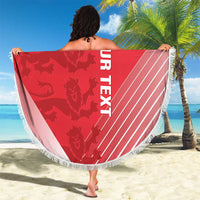 Red round beach blanket with fringed edge, held out with white “YOUR TEXT” print.