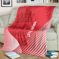 Red cricket blanket on armchair with crown graphic, diagonal paneling, and vertical 'YOUR TEXT'