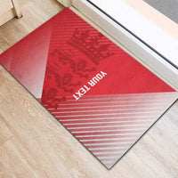 Red rubber doormat laid on floor, crown and animal silhouettes with diagonal light stripes