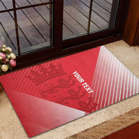Red cricket doormat with crown graphic, diagonal white stripes, custom text on entryway
