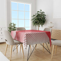 Red and pink striped tablecloth draped over a dining table with chairs.