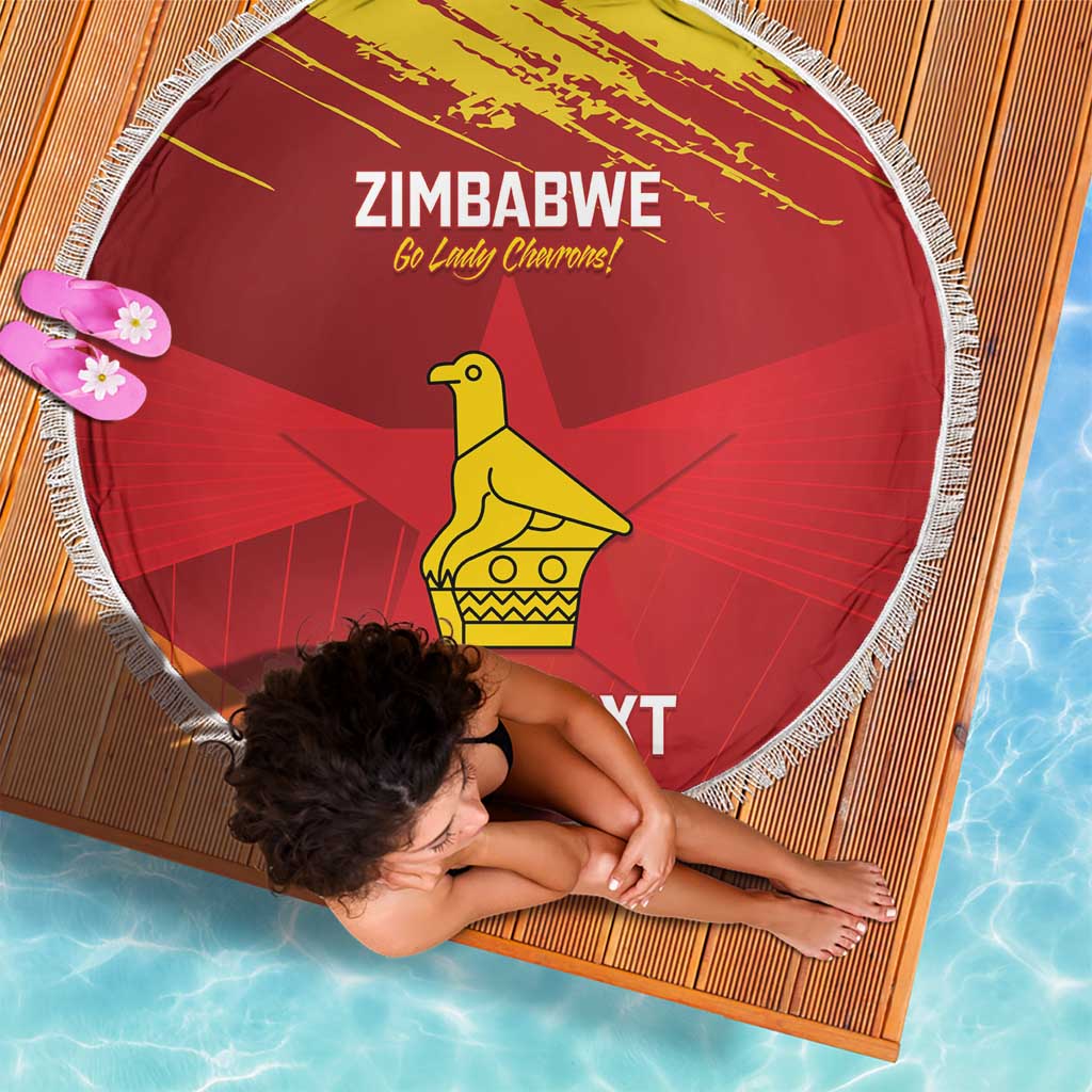 Red round beach blanket with white fringe, Zimbabwe text and yellow bird graphic.