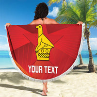 Red round beach blanket with white fringe, Zimbabwe flag graphic and yellow bird icon.