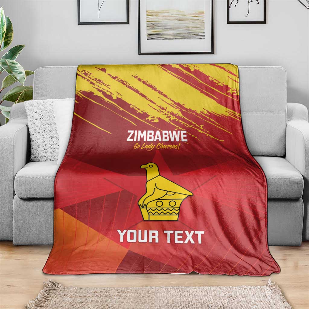 Zimbabwe cricket blanket draped on sofa, red with yellow emblem and “YOUR TEXT” print